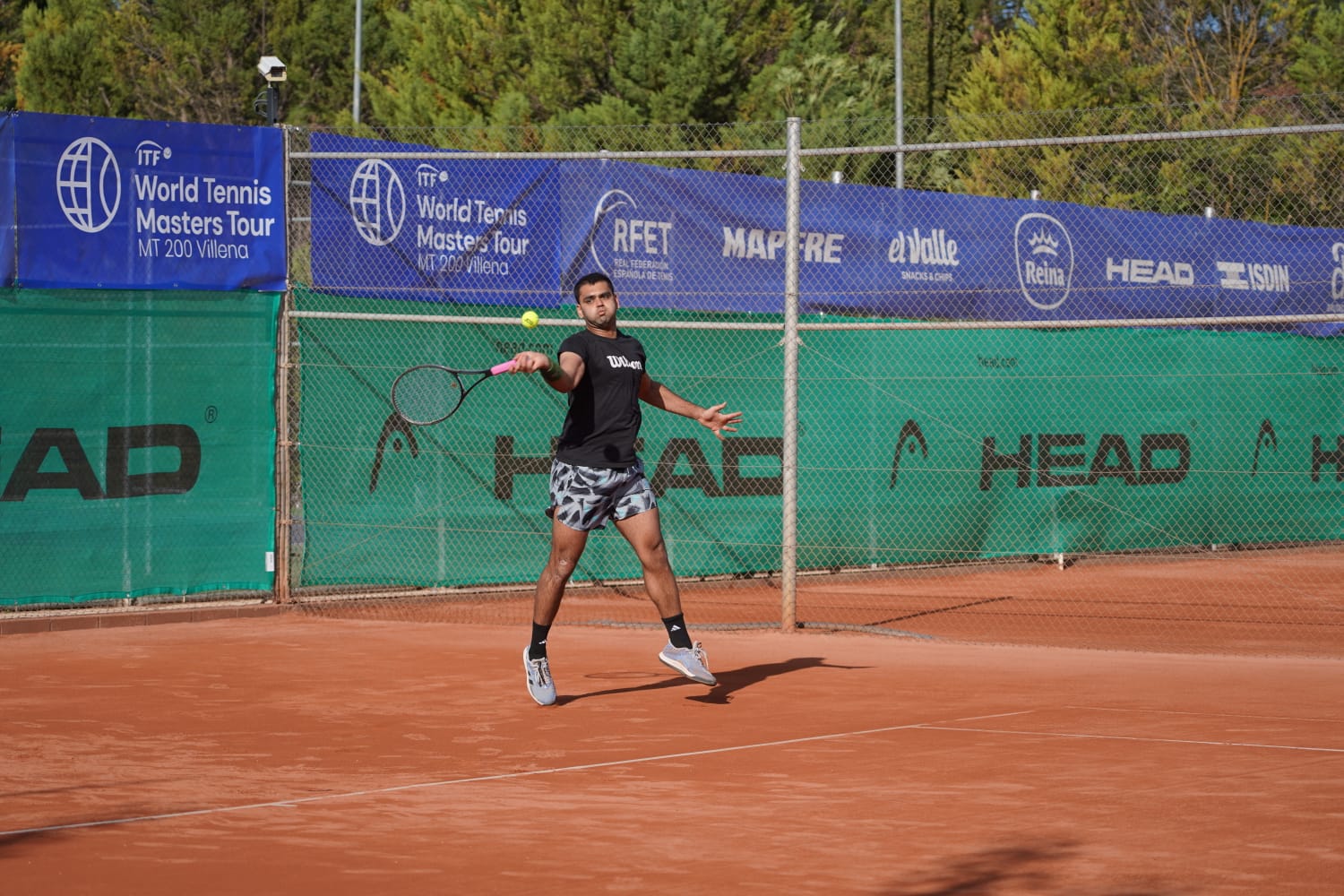 Manvir Randhawa playing a forehand on a clay court